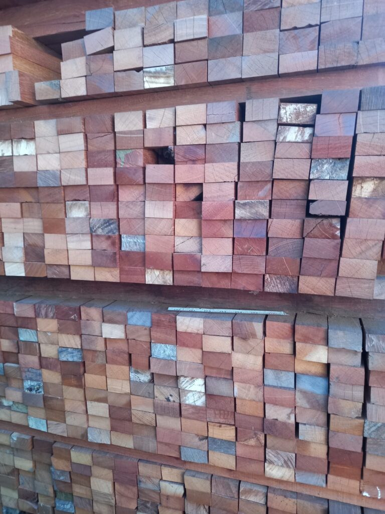 Tumpukan kayu balok tersusun di gudang